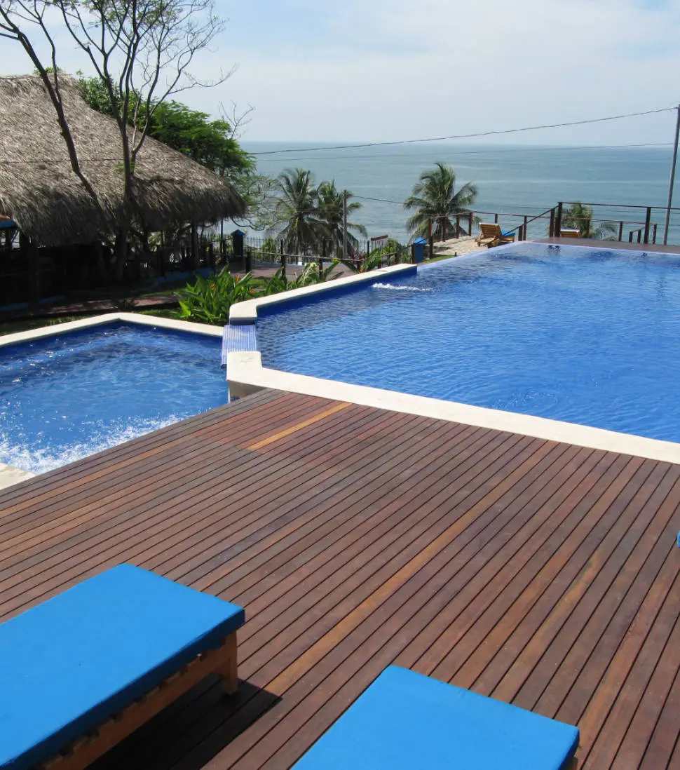 Kayu-Resort-hero-img-resort-pool-and-deck-with-palapa-and-pacific-ocean-trees-vertical-970x1098px-med-Kayu-Resort-photos-Tue-14-Mar-2023 970x1098px